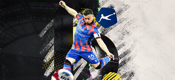 Fussballspieler im blauen und roten Trikot beim Torschuss